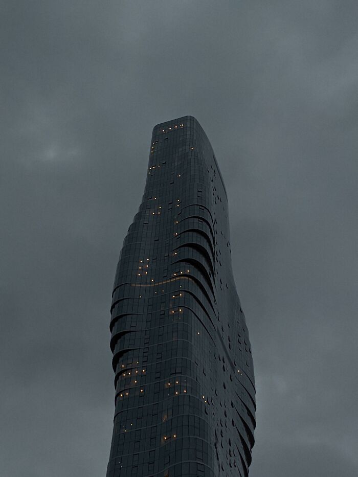 A dark, curvy building under a cloudy sky, suitable for an evil mastermind to plan world conquest.