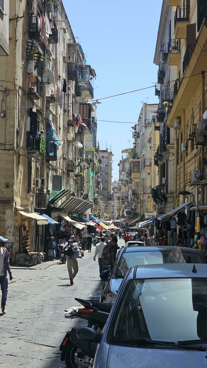 Urban hell crowded narrow street with old apartment buildings and parked cars