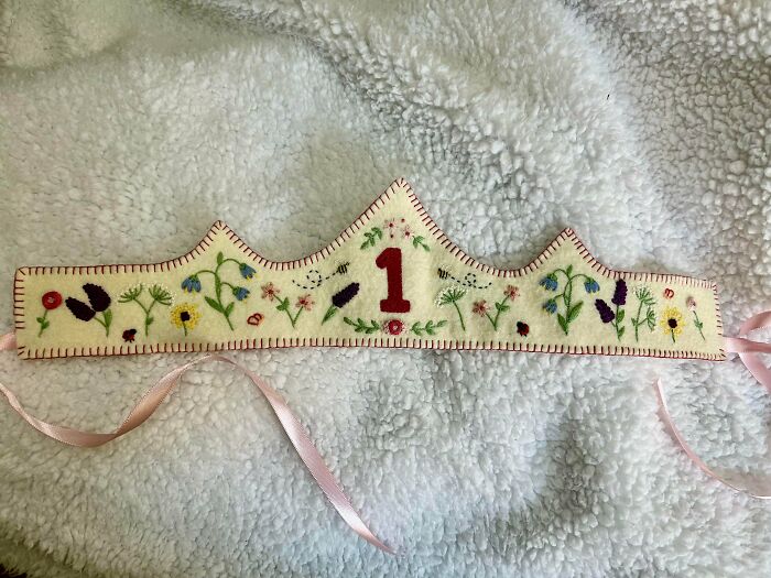 Handcrafted embroidery projects on a felt birthday crown decorated with colorful stitched flowers