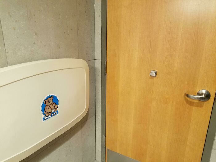 Baby changing station installed too close to a bathroom door