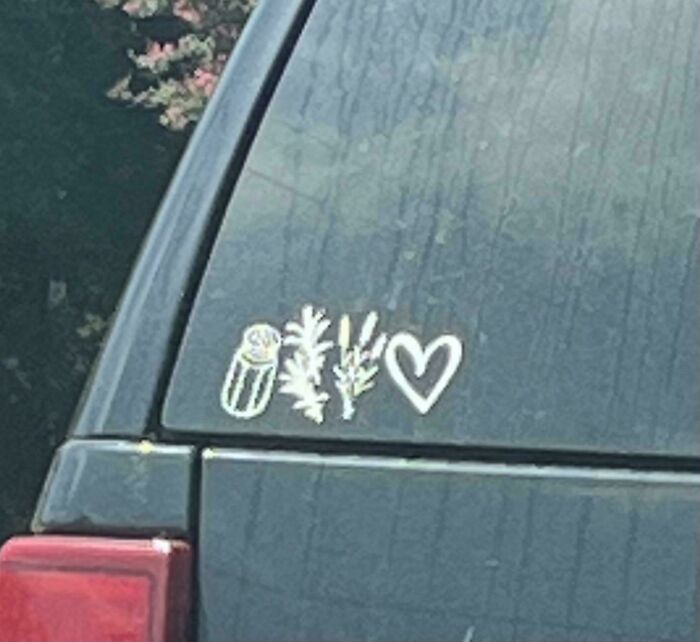 A bumper sticker on a dirty car window showing a salt shaker, herbs, and a heart. Interesting post on what this means.