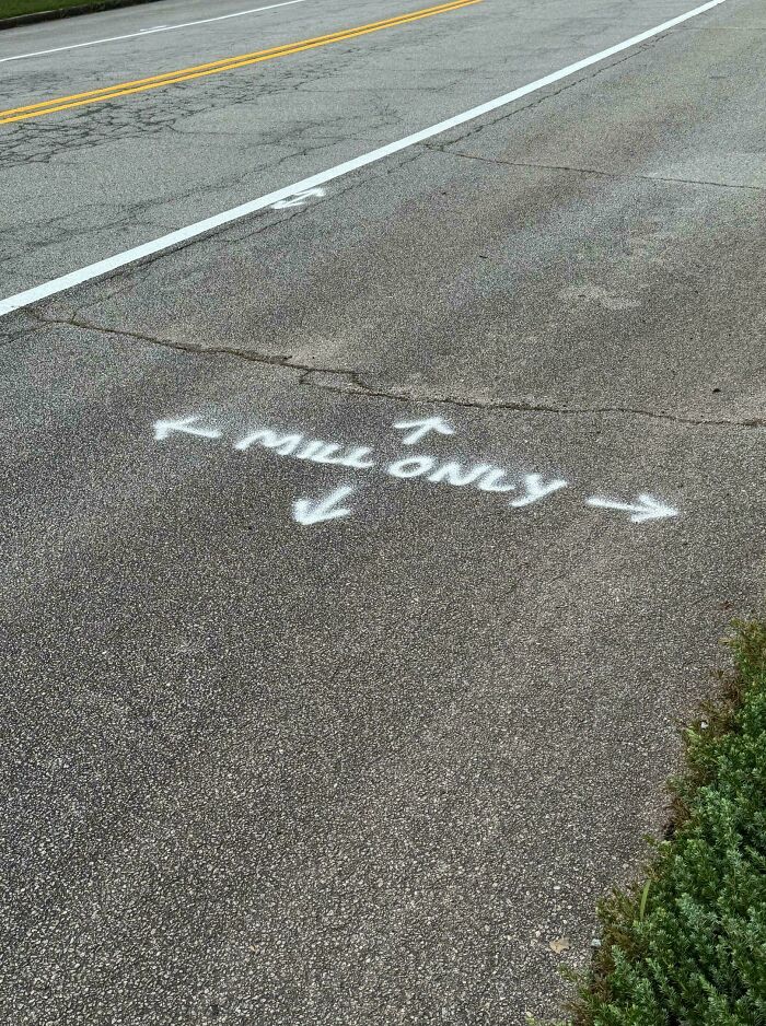 White spray-painted text on asphalt reads "MILL ONLY" with arrows, an interesting post for a group.