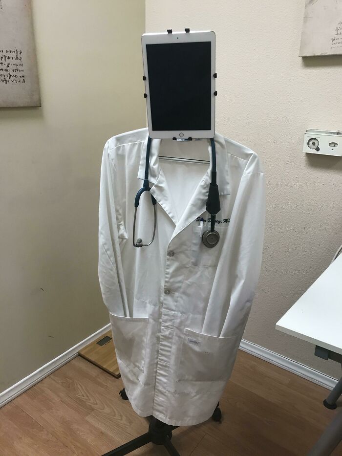 A doctor's white coat and stethoscope on a stand, with a tablet as the head. Showcasing doctors' awesome sense of humor.