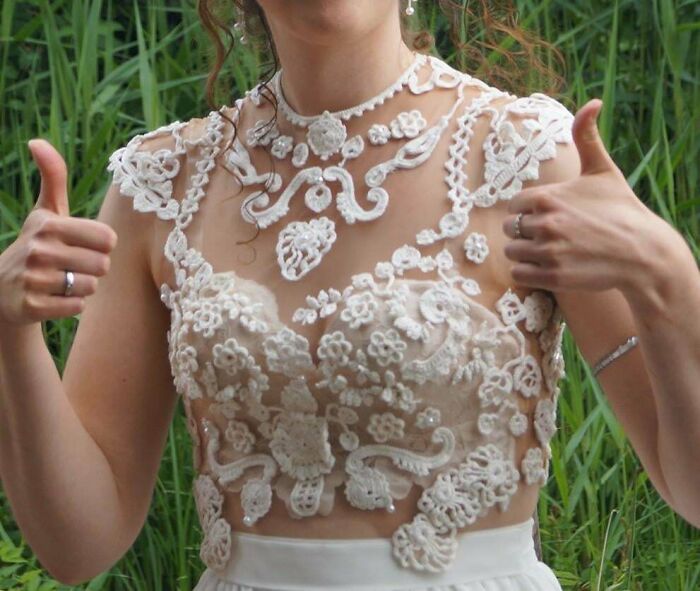 A woman proudly displaying a handmade top with intricate lace details, a talent-filled handmade project.
