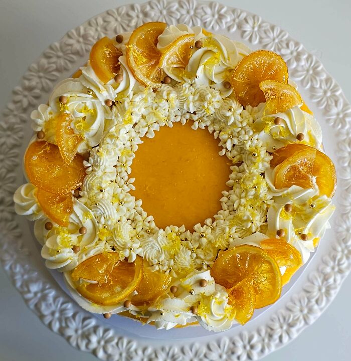 Orange and white decorated cake with whipped cream and candied orange slices dessert