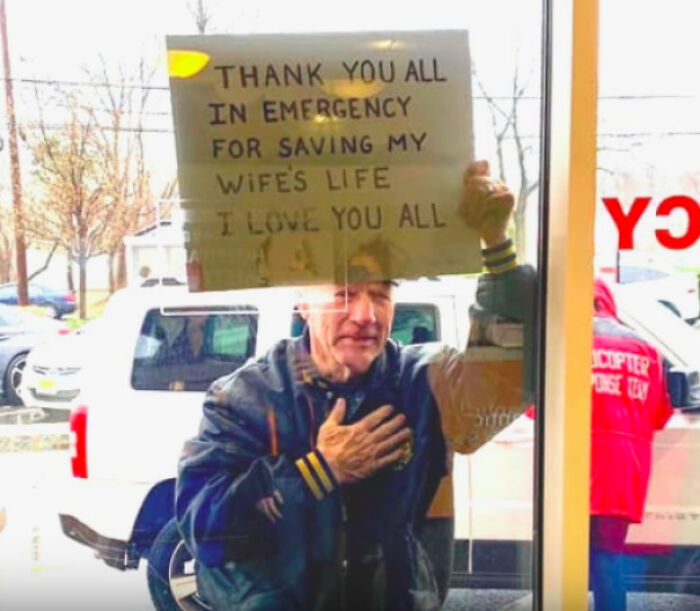 A man holding a thank you sign for emergency workers, hand on heart. A wholesome pic hitting hard.