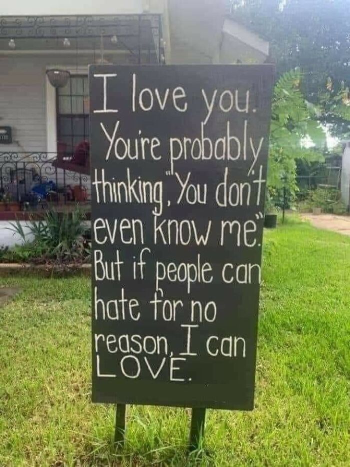 A wholesome pic of a yard sign reading, "I love you. You're probably thinking, You don't even know me. But if people can hate for no reason, I can LOVE."