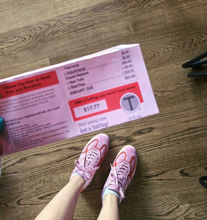 Feet in pink sneakers on a wooden floor, with a pink bill displaying an accidental color match. Satisfying photos lowering cortisol levels.
