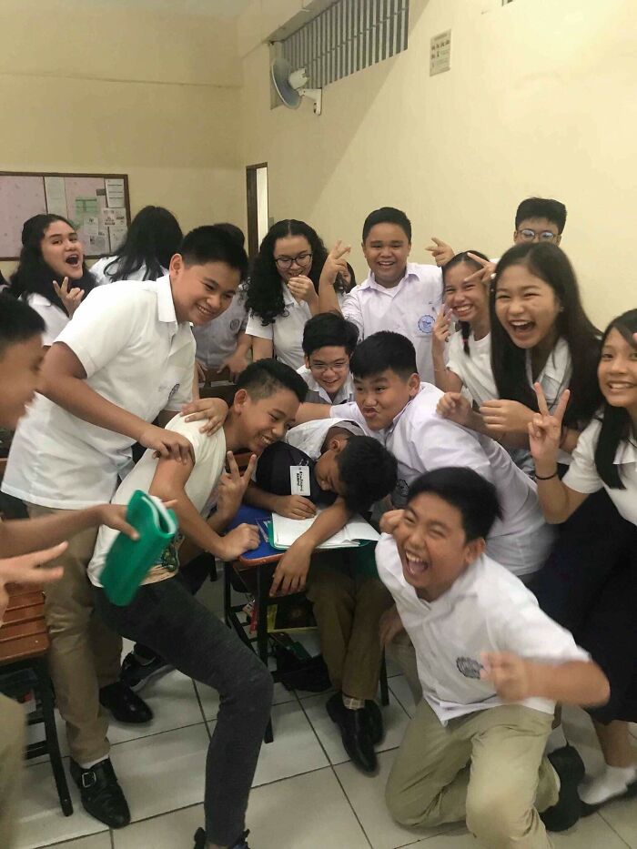 A group of students laughing and posing playfully in a classroom. Their joyful expressions make for wholesome pics.
