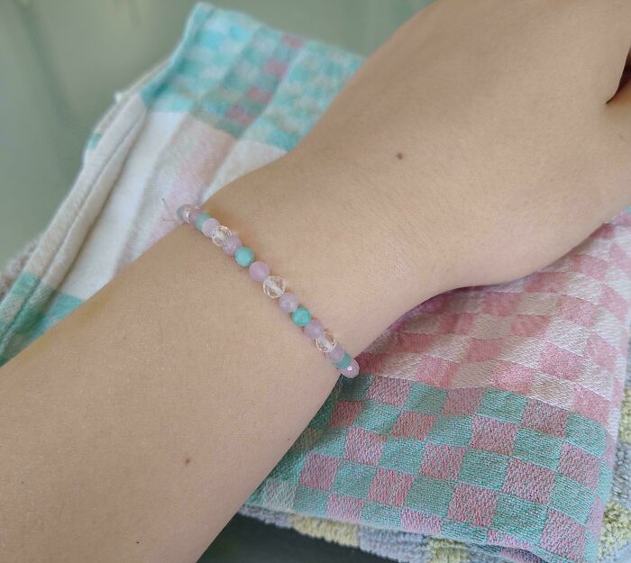 A pastel beaded bracelet on an arm, perfectly matching a checkered towel for accidental color matches, may lower your cortisol levels.