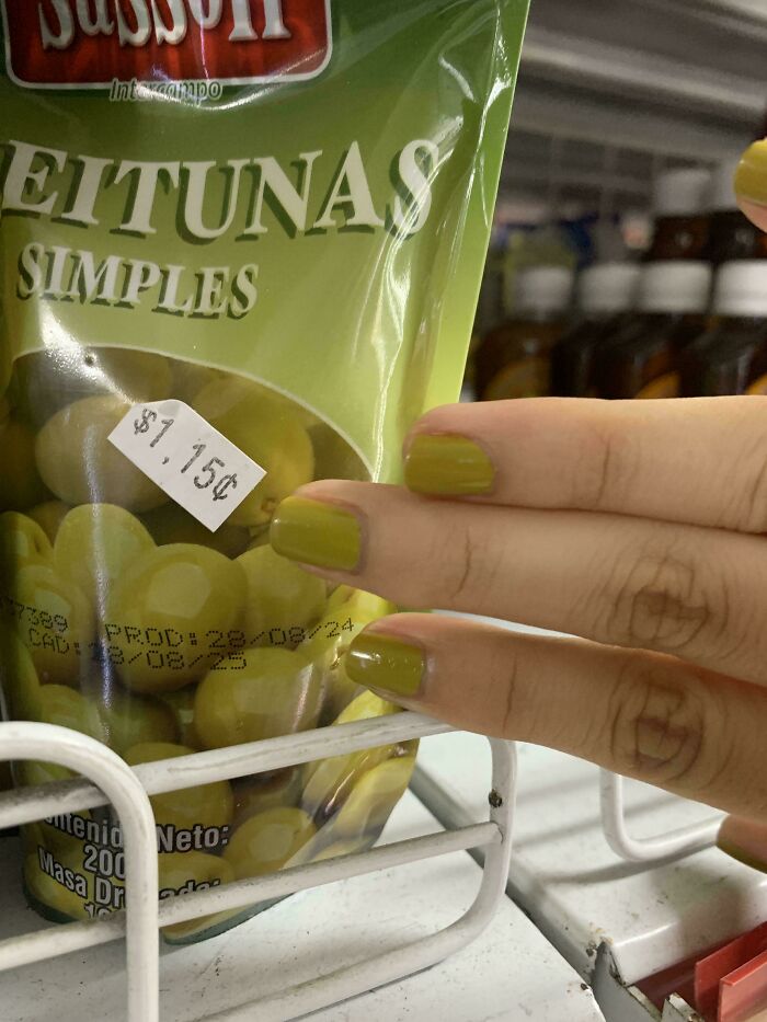 A hand with chartreuse nails aligns perfectly with a bag of green olives. An accidental color match that may lower your cortisol levels.