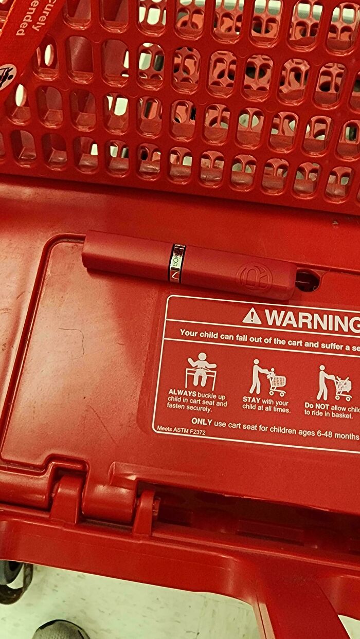 A red shopping cart with a warning label and a red lipstick tube perfectly matching its color. Accidental color matches can lower cortisol levels.