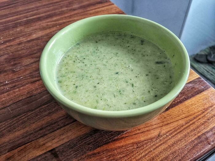 A light green bowl of soup with herbs, perfectly matching the bowl's color, offering accidental color matches.