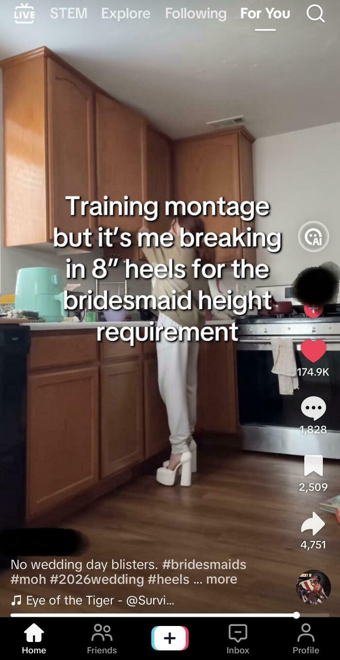 A woman in white platform heels in a kitchen. The video title says: Training montage but it's me breaking in 8" heels for the bridesmaid height requirement. This TikTok shows a woman preparing for a wedding, revealing the pressures to be perfect. The woman looks out of touch with reality.