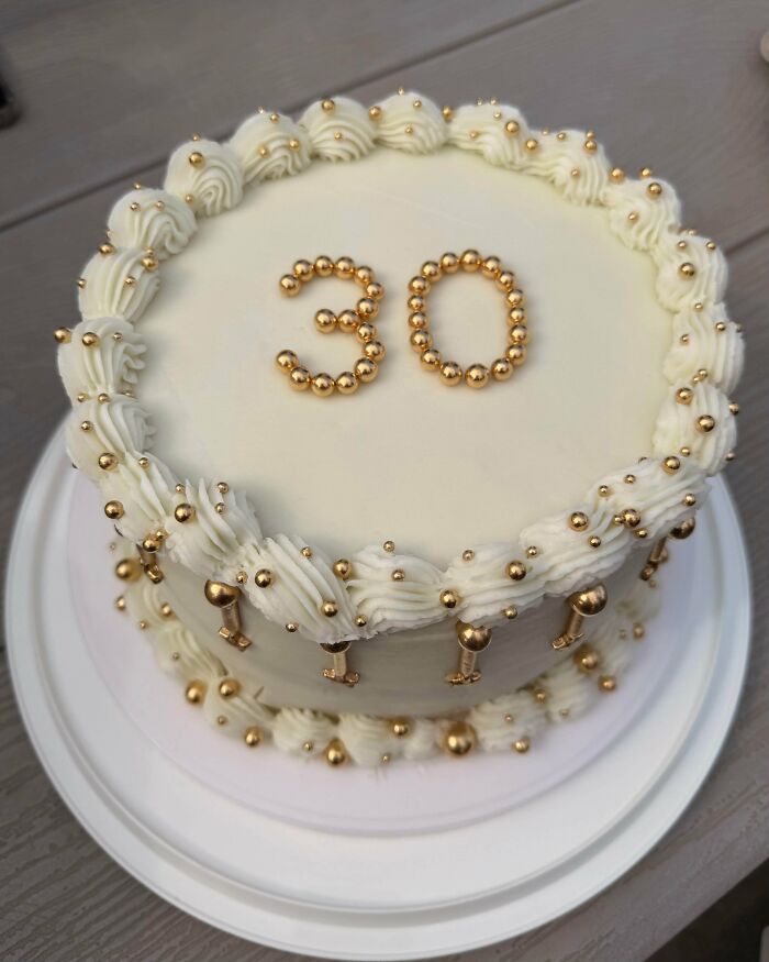 White frosted cake decorated with gold beads number 30 dessert