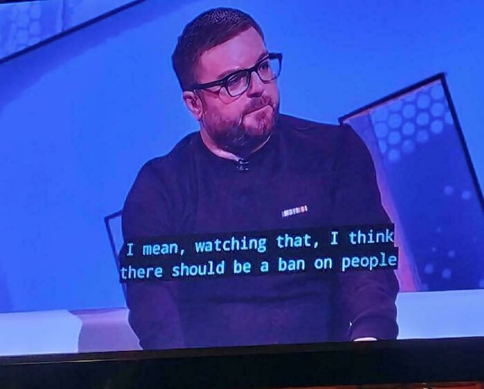 A man with a beard and glasses on a TV screen with a humorous instance of premature truncation in the subtitles.