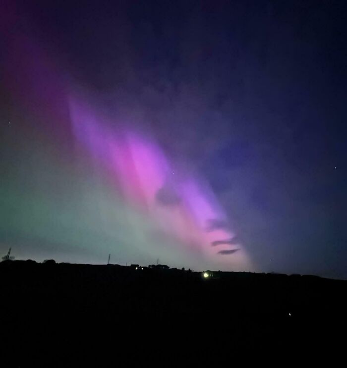Pareidolia in colorful northern lights resembling a face in the night sky