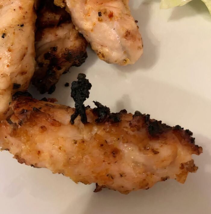 Burnt chicken wing with burnt mark shaped like a tiny person in pareidolia