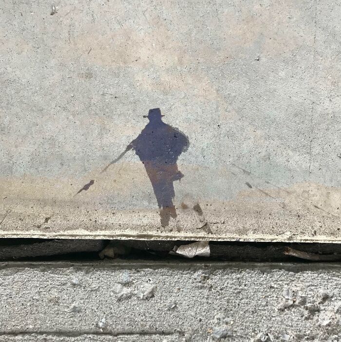 Sidewalk stain shaped like a person walking with sticks illustrating pareidolia