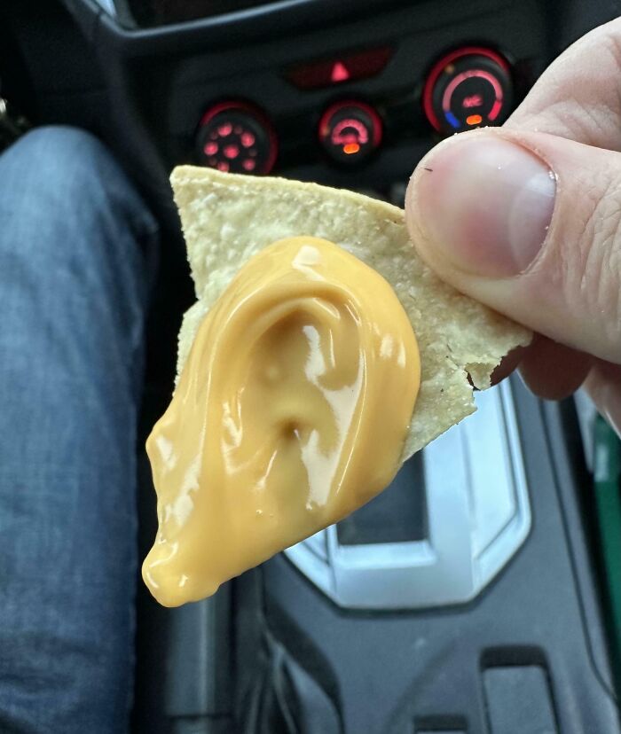Close up of chip with cheese dip shaped like an ear showing pareidolia