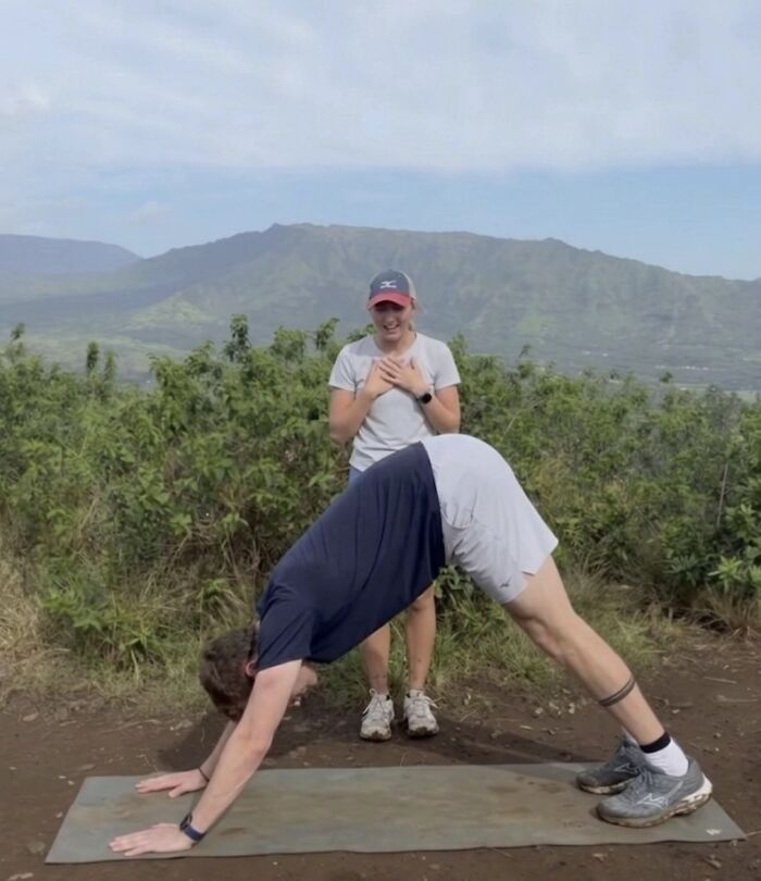 Woman reacts happily as a man does a yoga pose, hinting at a proposal pic, inspiring hilarious edits.