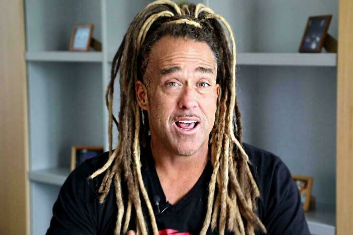 Man with long, blonde dreadlocks representing an unfortunate haircut, speaking to the camera.