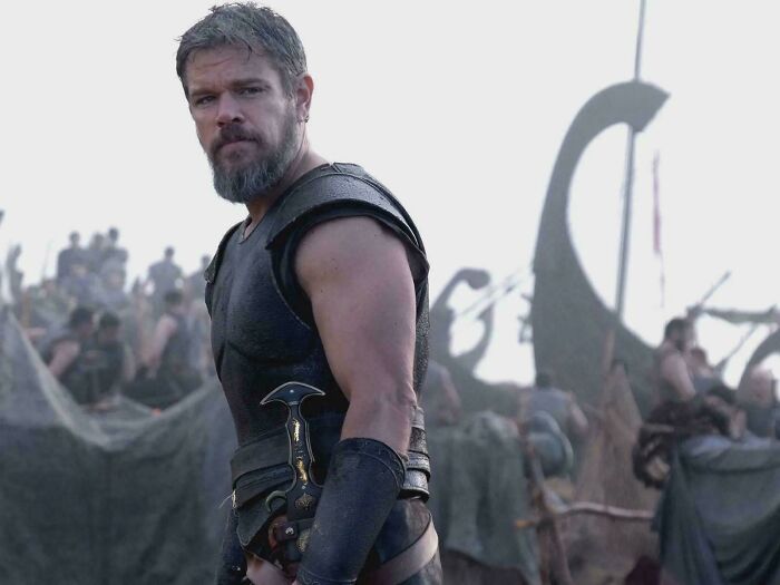 Matt Damon in ancient warrior attire with a beard, holding a dagger, from a scene with nonsensical movie details.