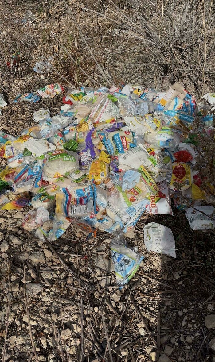 Large pile of discarded bread bags dumped in a wooded area