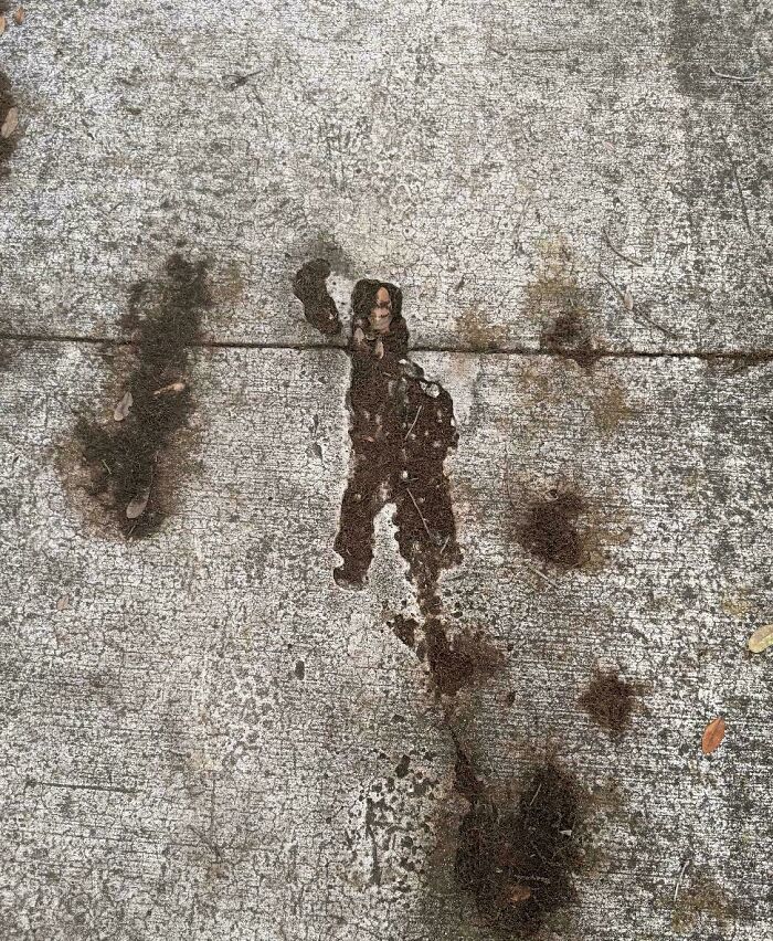 Oil stain on concrete resembling a human silhouette