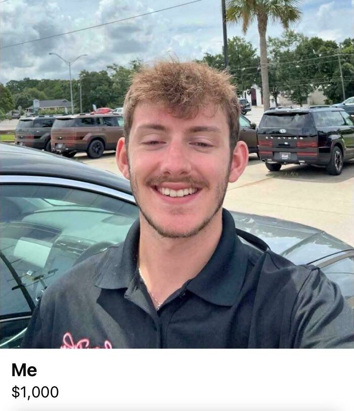 Smiling man taking selfie near parked cars under blue sky