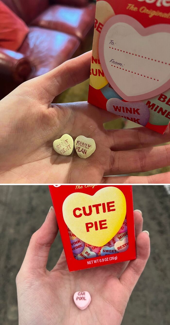 Hand holding heart shaped candies with funny sayings and related candy box
