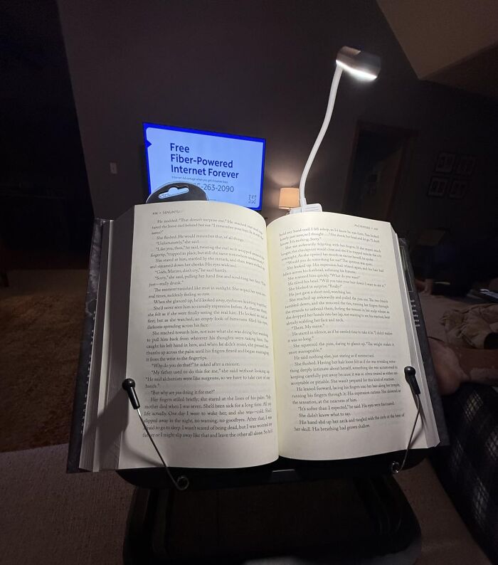 A brightly lit book with a book light, perfect for last minute Mother's Day gifts for book-loving moms.
