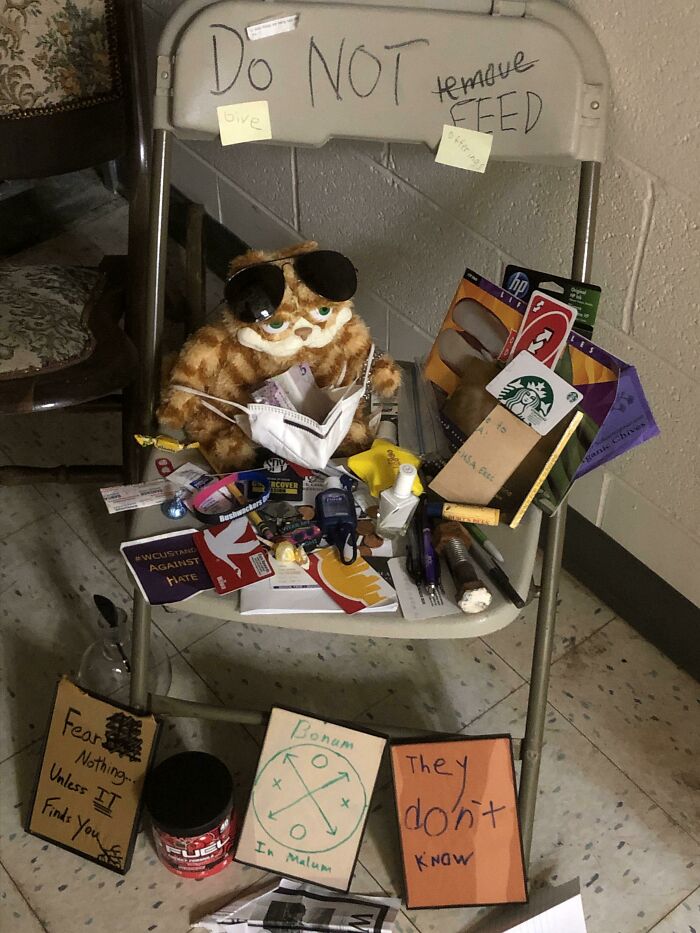 Chair filled with assorted student items under a do not feed sign