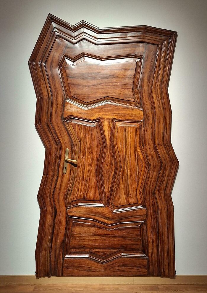 Distorted wooden door with warped panels and handle