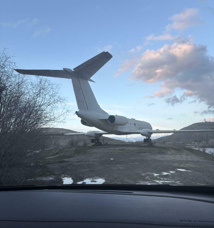 Abandoned airplane on rough terrain under cloudy sky
