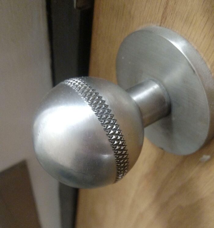 Textured metal doorknob in a school hallway