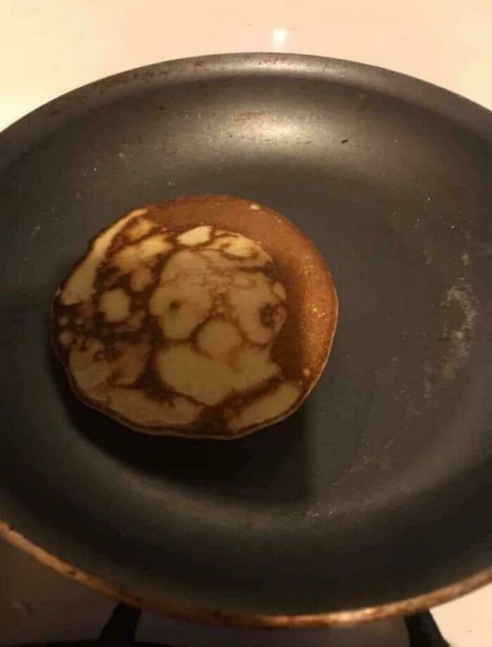 Pancake with cooked patterns resembling a human face pareidolia