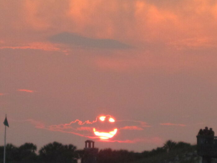 Sunset with clouds forms a smiley face in the sky at dusk