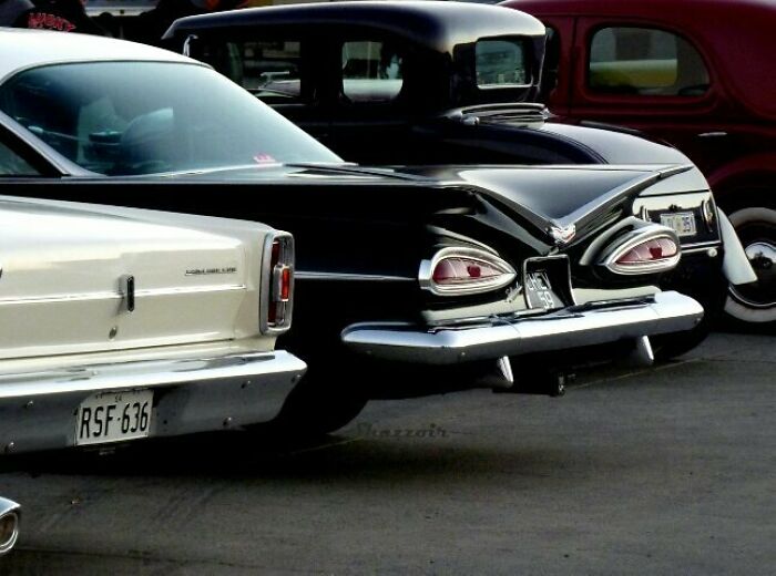 Backs of classic cars with taillights resembling eyes and a mouth