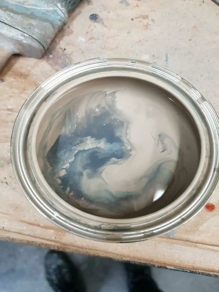 Open paint can with swirling paint that creates a dragon-like figure by pareidolia