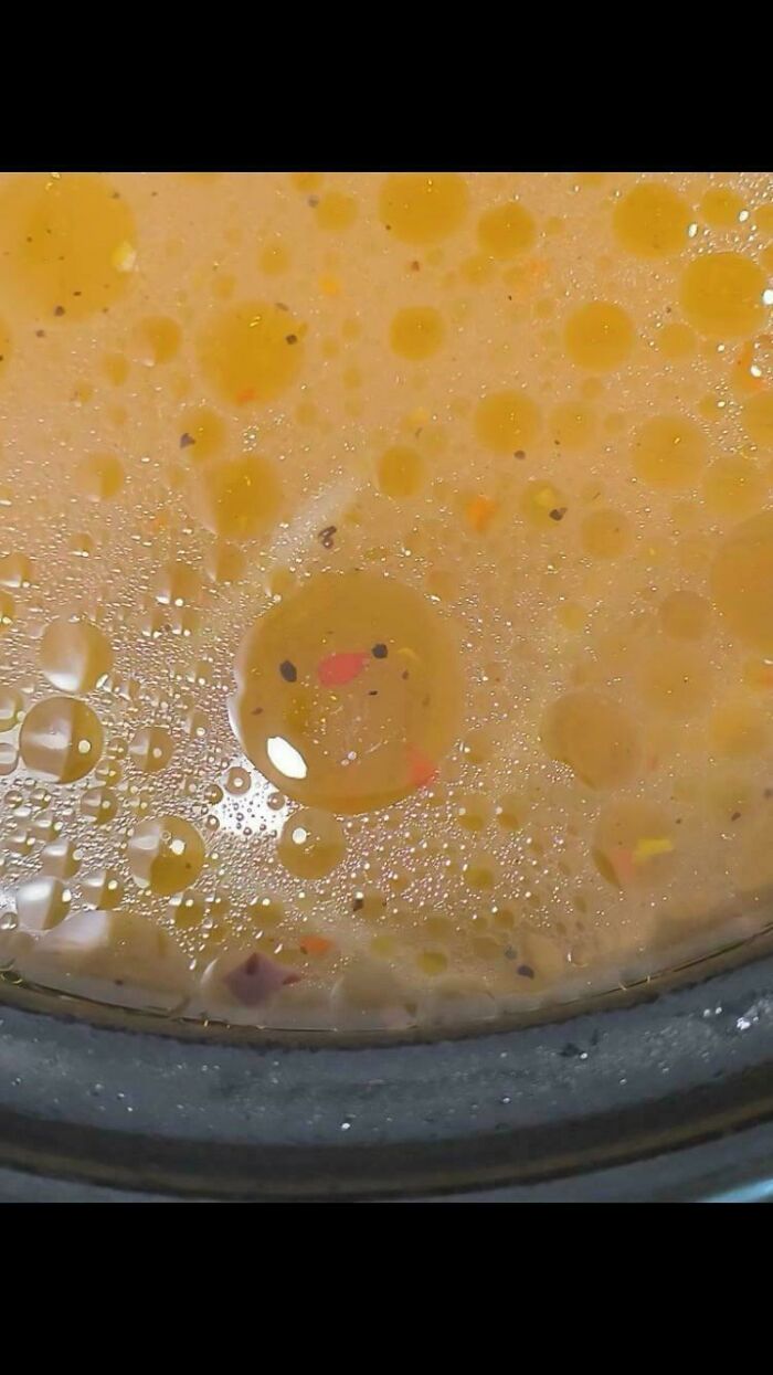 Oil droplets in soup forming a face pattern by pareidolia
