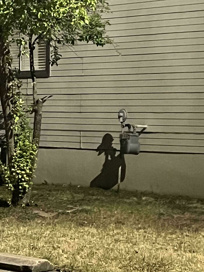 Shadow on wall from pipe resembling a person silhouette