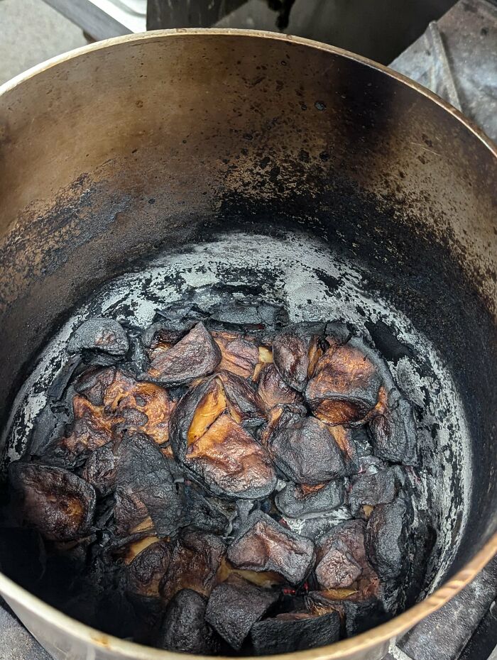 Burnt food residue inside large blackened pot kitchen fail