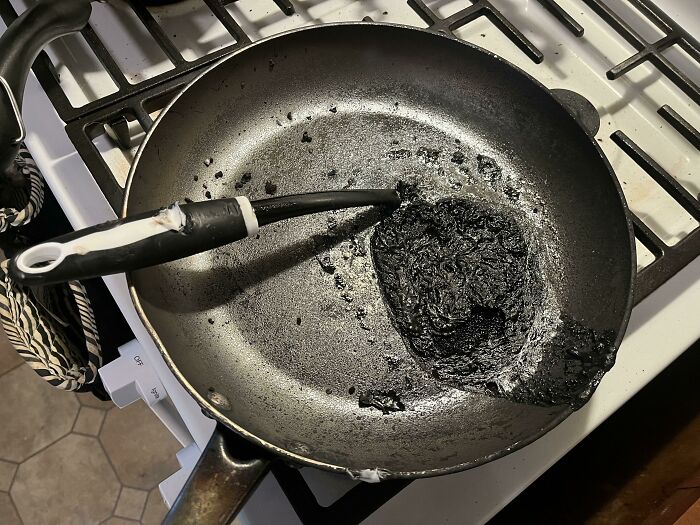 Burnt frying pan with melted handle on stove kitchen fail