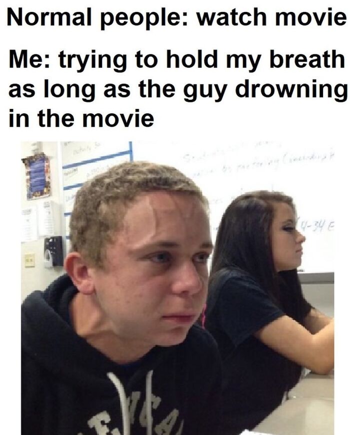 A male student with visible veins straining his neck and forehead, illustrating a relatable meme about holding breath during a movie.