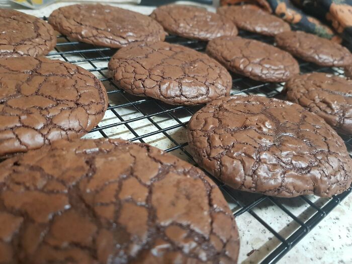 Freshly baked chocolate cookies cooling on rack with cracked surface