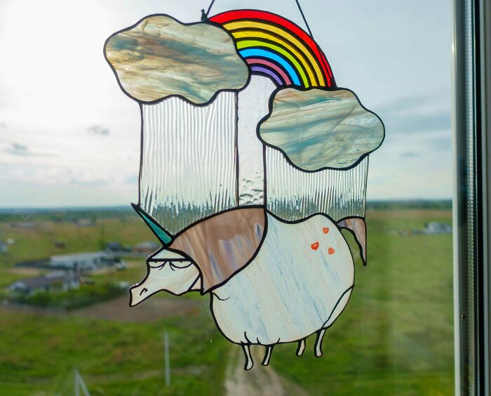 A handmade stained-glass unicorn with a rainbow and clouds, a project showing talent and patience.