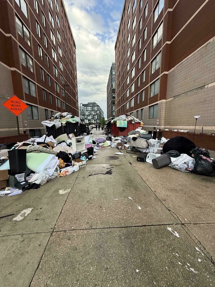 An alley filled with excessive trash and discarded items, highlighting the impact of insulting consumerism and price difference.