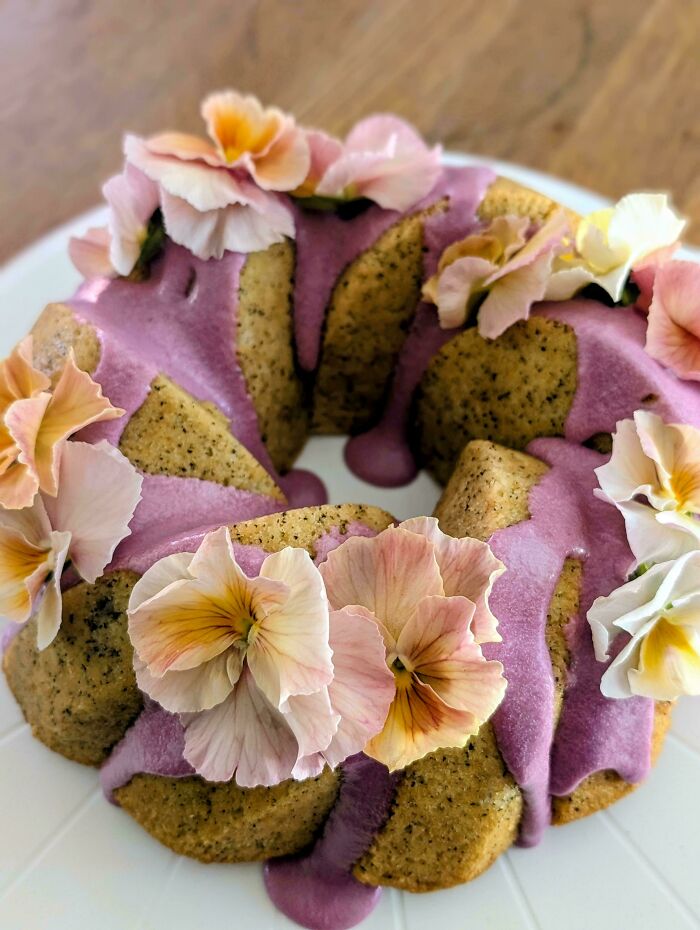 Bundt cake with purple frosting and pansy flower decorations