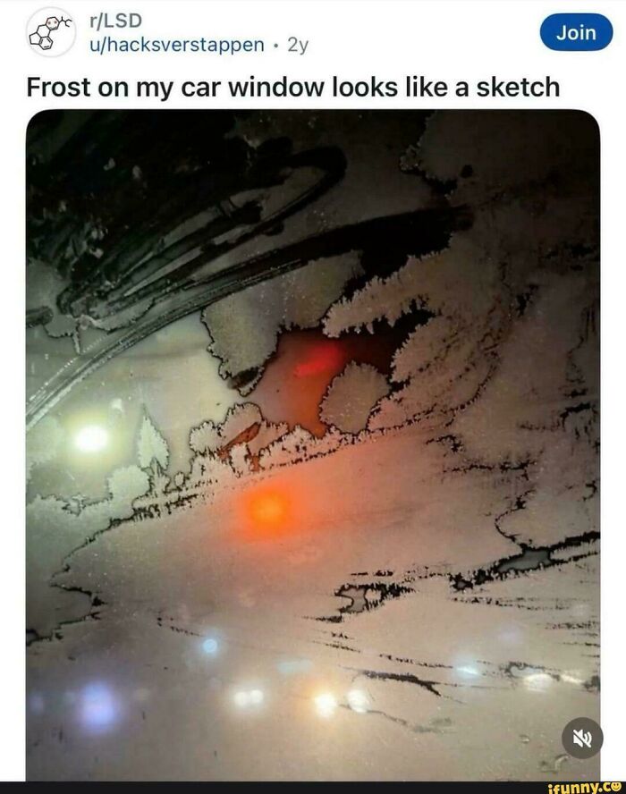 Frost on car window resembling a detailed sketch with blurred traffic lights in the background